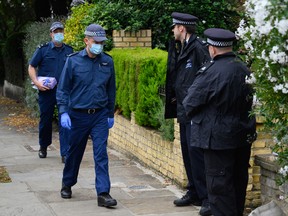 Members of a police search team enter a residence on October 17, 2021 in the Kentish Town neighborhood of London, England.
