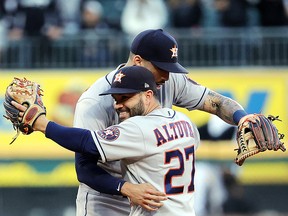 Jose Altuve and Carlos Correa of the Houston Astros celebrate after beating the Chicago White Sox at Guaranteed Rate Field on October 12, 2021 in Chicago.