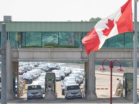 Travellers wait to cross into Canada at the Rainbow Bridge in Niagara Falls, Ontario, August 9, 2021 as Canada reopens for non-essential travel to fully vaccinated Americans.