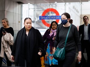 Commuters, some wearing face coverings to help prevent the spread of coronavirus, walk out of a Transport for London underground train station in London on Oct. 20, 2021.
