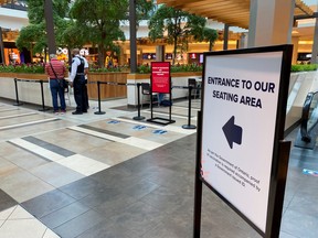 A security guard checks for proof of vaccination at the entrance to a food court during phase one of Ontario's vaccine certification program in Toronto, Sept. 22, 2021.