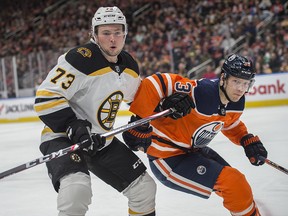 Alex Chiasson of the Edmonton Oilers chases the puck into the corner with Charlie McAvoy of the Boston Bruins at Rogers Place in Edmonton on February 19, 2020.