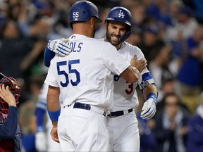 Los Angeles Dodgers first baseman Albert Pujols, left, celebrates after scoring on a two run home run hit by left fielder Chris Taylor in the fifth inning against the Atlanta Braves during game five of the 2021 NLCS at Dodger Stadium in Los Angeles, Calif., Oct. 21, 2021.
