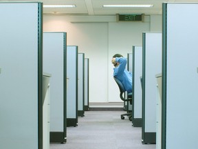 A man is seen reclining on his chair in cubicle in an office in this file photo.