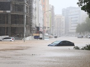 Cars are seen abandoned on a flooded street as Cyclone Shaheen makes landfall in Muscat Oman, Oct. 3, 2021.
