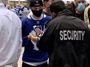 A security guard checks a fan's vaccine passport at Wednesday night's Leafs game.