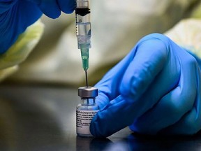 A health-care worker prepares a dose of the Pfizer-BioNTech COVID-19 vaccine at a University Health Network vaccine clinic in Toronto on Jan. 7, 2021.