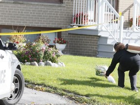 A neighbour drops off flowers on Oct. 31, 2021  in front of the North York home where 67-year old Vincenza Galloro was murdered.