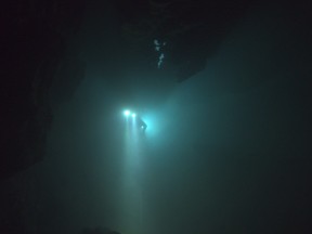 A diver floats through an underwater cave.  THE RESCUE chronicles the 2018 rescue of 12 Thai boys and their soccer coach, trapped deep inside a flooded cave. E. Chai Vasarhelyi and Jimmy Chin reveal the perilous world of cave diving, bravery of the rescuers, and dedication of a community that made great sacrifices to save these young boys.