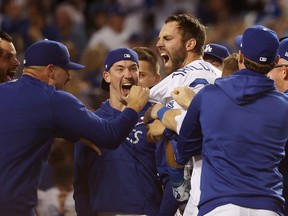 Chris Taylor of the Los Angeles Dodgers celebrates with teammates after his walk off two-run home run in the ninth inning to defeat the St. Louis Cardinals at Dodger Stadium on October 6, 2021 in Los Angeles.