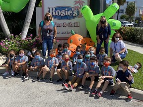 Elementary school students and chaperones posing outside a Florida bar and grill.
