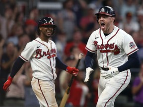 Atlanta Braves first baseman Freddie Freeman (right) celebrates with  second baseman Ozzie Albies (left) after hitting a home run against the Milwaukee Brewers at Truist Park.