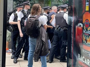 Britain's Housing Secretary Michael Gove walks while surrounded by police officers and protesters, in London October 19, 2021, in this still image obtained from a social media video.