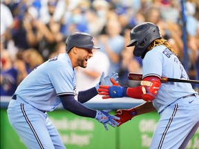 George Springer of the Blue Jays (left) celebrates his homecoming with teammate Vladimir Guerrero Jr.  during the first round against the Baltimore Orioles at Rogers Center on Sunday, October 3, 2021.
