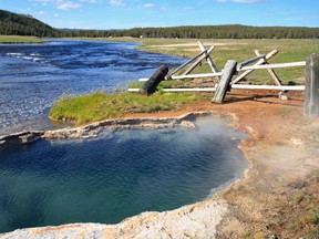Maiden's Grave Hot Spring flowing into the Firehole River in Yellowstone National Park in Wyoming.