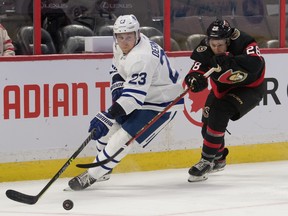 Maple Leafs defenceman Travis Dermott (23) controls the puck against Ottawa Senators right wing Connor Brown (28) in the second period at the Canadian Tire Centre Sept. 29, 2021.