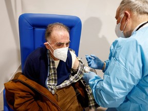 An elderly man receives a dose of the Moderna vaccine against COVID-19 at the Music Auditorium in Rome, Feb. 15, 2021.