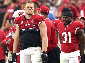 J.J. Watt (left) of the Arizona Cardinals looks on in the fourth quarter against the Houston Texans at State Farm Stadium on October 24, 2021 in Glendale, Arizona.