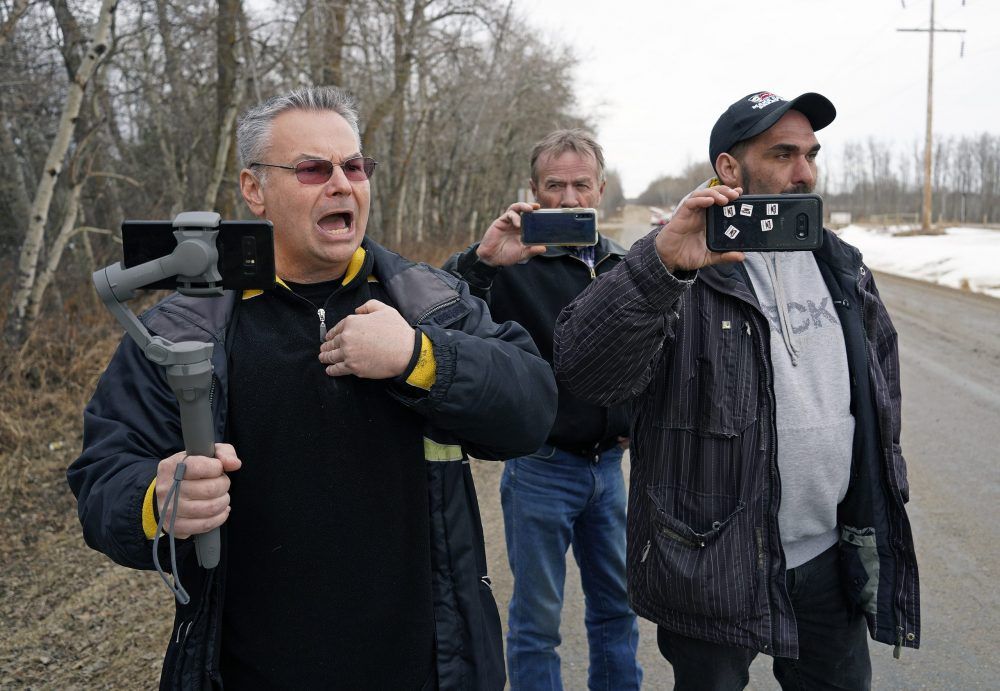 Kevin J. Johnston, left, along with some sidekicks, harass a Postmedia  photojournalist outside of Edmonton on March 14, 2021. 