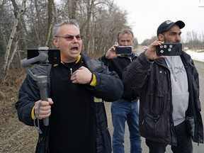 Kevin J. Johnston, left, along with some sidekicks, harass a Postmedia  photojournalist outside of Edmonton on March 14, 2021.