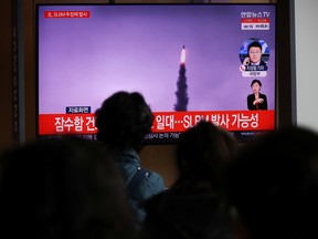 People watch a TV broadcasting file footage of a news report on North Korea firing a ballistic missile off its east coast, in Seoul, South Korea, October 19, 2021.