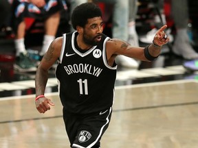 Brooklyn Nets point guard Kyrie Irving (11) reacts after making a basket against the Milwaukee Bucks at Barclays Center.