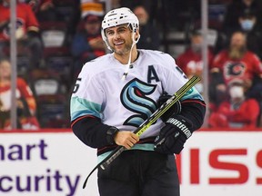 Kraken defenceman Mark Giordano smiles as he takes his broken stick back to the bench after taking his shot in a shootout against the Flames during a pre-season game at Scotiabank Saddledome in Calgary, Sept. 29, 2021.