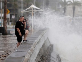 A man speaks on his mobile phone as hurricane Pamela pounds the Pacific coast resort with strong winds as it makes landfall in Mazatlan, Mexico October 13, 2021.