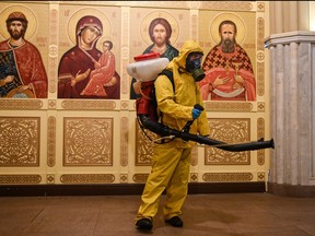 A serviceman of Russia's Emergencies Ministry wearing protective gear disinfects an Orthodox chapel at Moscow's Leningradsky railway station on Oct. 19, 2021, amid the ongoing coronavirus disease pandemic.