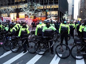 In this file photo taken on December 11, 2020, police officers stand guard after a car struck multiple Black Lives Matter protesters in New York
