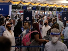 Passengers gather near Delta airline's counter as they check-in their luggage at Hartsfield-Jackson Atlanta International Airport, in Atlanta, Ga., May 23, 2021.