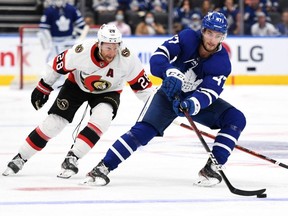 Maple Leafs forward Pierre Engvall (right) carries the puck past Senators forward Connor Brown (left) during preseason NHL action at Scotiabank Arena in Toronto, Saturday, Oct. 9, 2021.