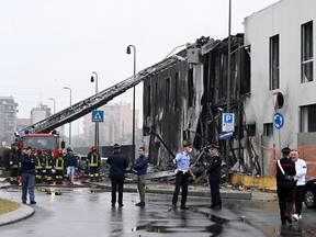 Emergency personnel works at the scene where a small plane crashed into a building in San Donato Milanese, Italy, Oct. 3, 2021.