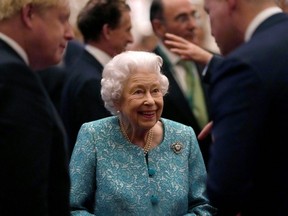 Britain's Queen Elizabeth and Prime Minister Boris Johnson greet guests at a reception for the Global Investment Summit at Windsor Castle, Windsor, England, Oct. 19, 2021.