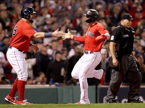 Red Sox players Kyle Schwarber, left, and Enrique Hernandez, right, celebrate after scoring against the Yankees during the seventh inning of the American League Wild Card game at Fenway Park in Boston, Tuesday, Oct. 5, 2021.