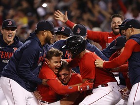 Enrique Hernandez of the Boston Red Sox celebrates with teammates after they defeated the Tampa Bay Rays in the American League Division Series at Fenway Park on October 11, 2021 in Boston.