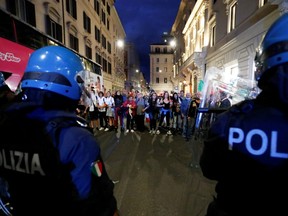 Demonstrators face off with police officers during a protest against the government's introduction of the "Green Pass" near Chigi Palace in Rome, Italy, Saturday, Oct. 9, 2021.