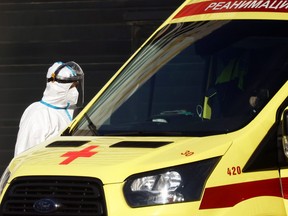 A medical specialist stands by an ambulance outside a hospital for patients infected with the COVID-19 in Moscow, Oct. 6, 2021.