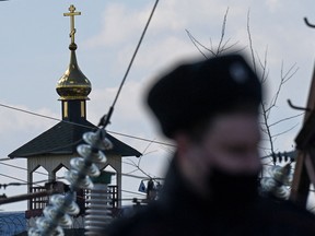 A Russian police officer patrols outside the territory of the penal colony N2 with an Orthodox church on the grounds where Kremlin critic Alexei Navalny has been transferred to serve a two-and-a-half year prison term for violating parole, in the town of Pokrov on April 6, 2021.