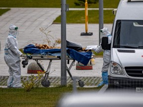 Medical staff members carry a person on a stretcher at the COVID-19 infected patients section at the Kommunarka Hospital outside Moscow, Friday, Oct. 15, 2021.