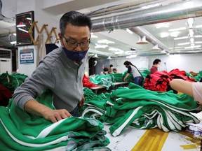 Ko Jong-hyun, 59, a clothing factory owner, checks newly made tracksuits inspired by Netflix series "Squid Game" at his plant in Seoul, Oct. 21, 2021.