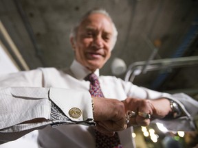 Paul Godfrey poses with "SUN" cufflinks after news conference in 2015.