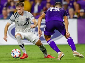 CF Montréal midfielder Djordje Mihailovic (left) moves the ball past Orlando City defender Rodrigo Schlegel at Orlando City Stadium on Oct. 20, 2021.