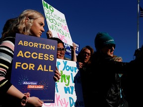 Pro-choice demonstrators hold up signs during a group chant outside of the U.S. Supreme Court on Capitol Hill in Washington, March 4, 2020.