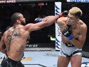 In this handout photo provided by UFC, Thiago Santos, left, of Brazil punches Johnny Walker of Brazil in their light heavyweight bout during the UFC Fight Night event at UFC APEX on Oct. 2, 2021 in Las Vegas, Nevada.