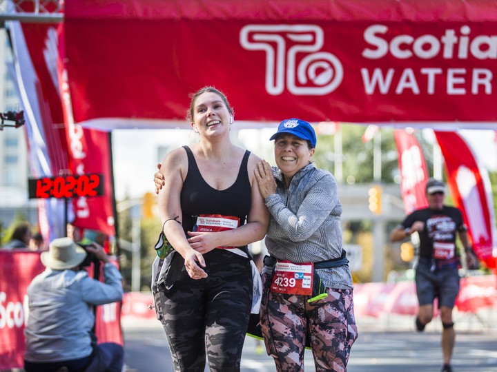  Jessica Riley (left) and Michelle Dilella after crossing the finish line at the Scotiabank Toronto Waterfront Marathon 10-kilometre run on Oct. 17, 2021. (Ernest Doroszuk/Toronto Sun)