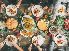 Friends eating at Thanksgiving Day table with vegetarian meals