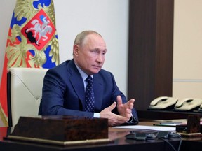 Russian President Vladimir Putin attends a meeting with members of the Security Council via a video link at his residence outside Moscow, Monday, Oct. 11, 2021.