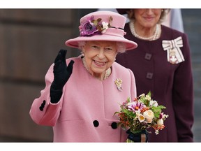 In this file photo taken on October 14, 2021 Queen Elizabeth II waves as she leaves after attending the ceremonial opening of the sixth Senedd, the Welsh Parliament, in Cardiff, Wales.
