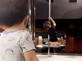 Baby boy watching dancer rehearsing on stripper pole.